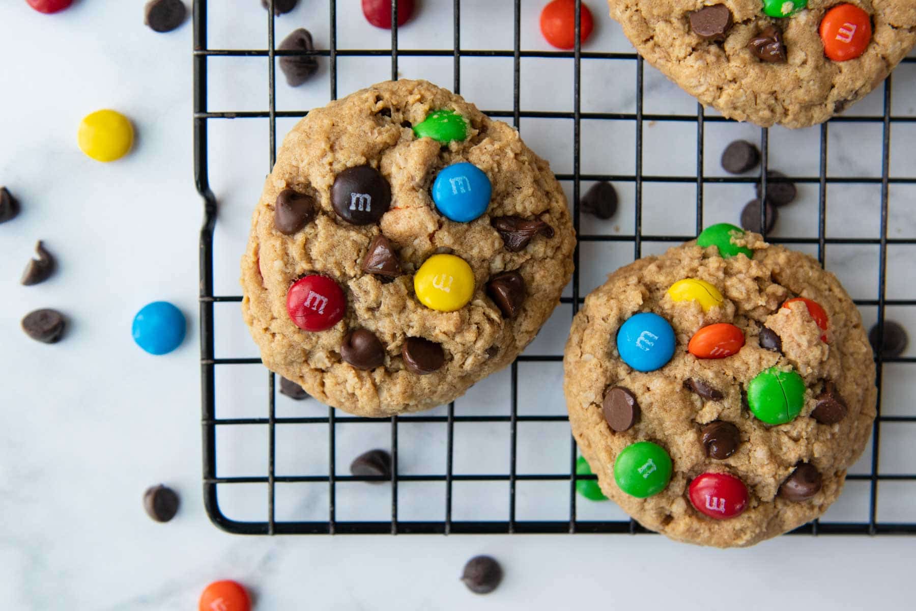 cookies on a cooling rack with m&m candies laying around