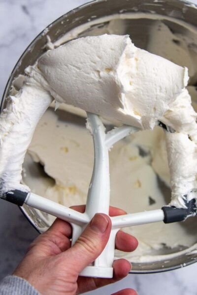 a beater holding up a buttercream frosting