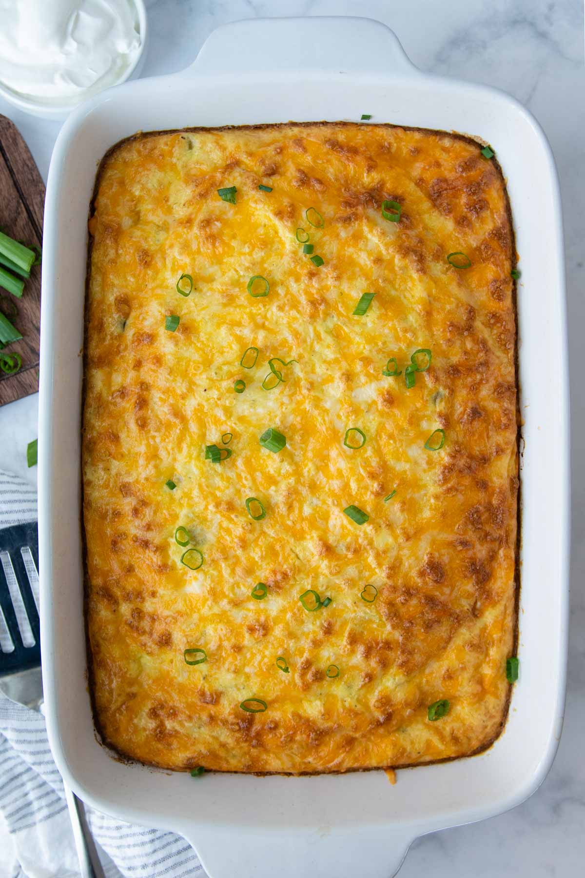a baked egg casserole with a green onions sprinkled on top