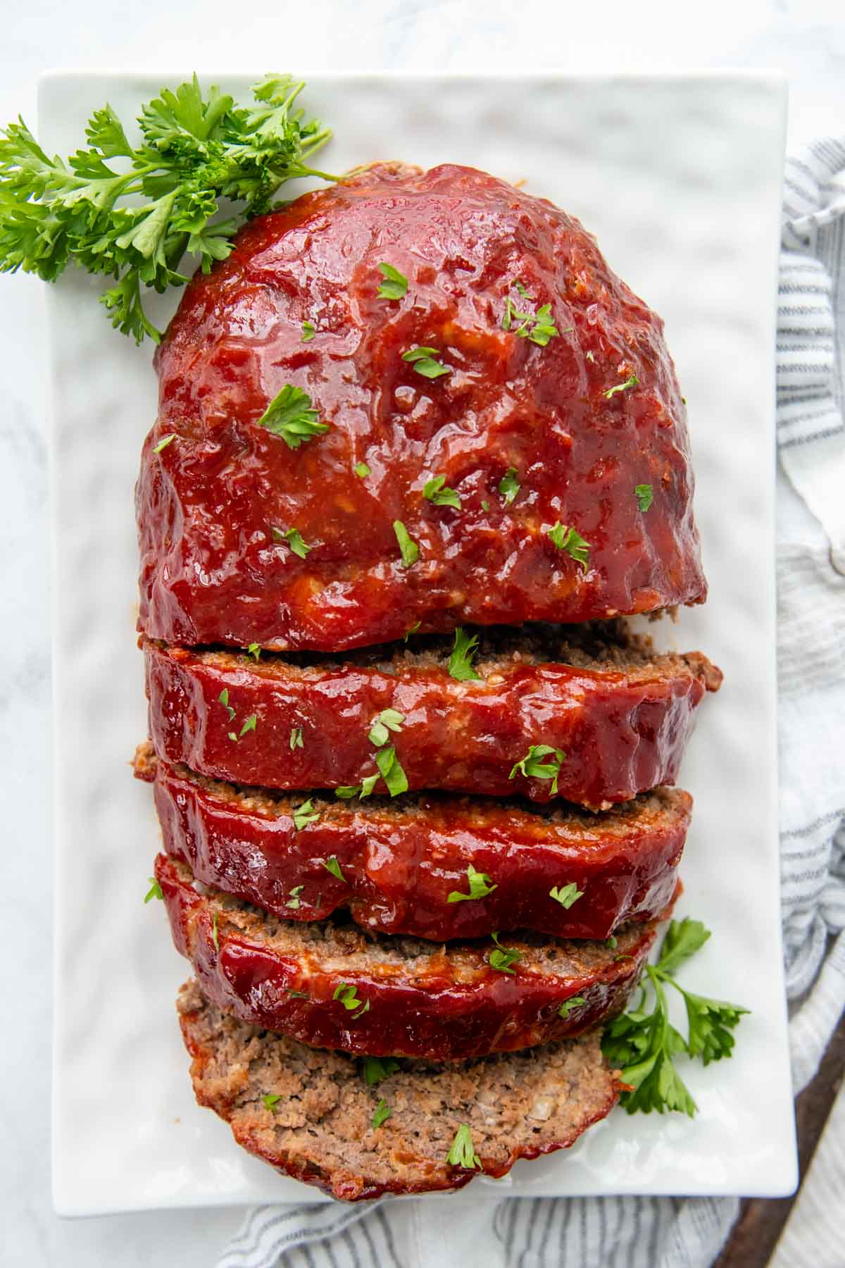overhead shot of sliced meatloaf on a white plate
