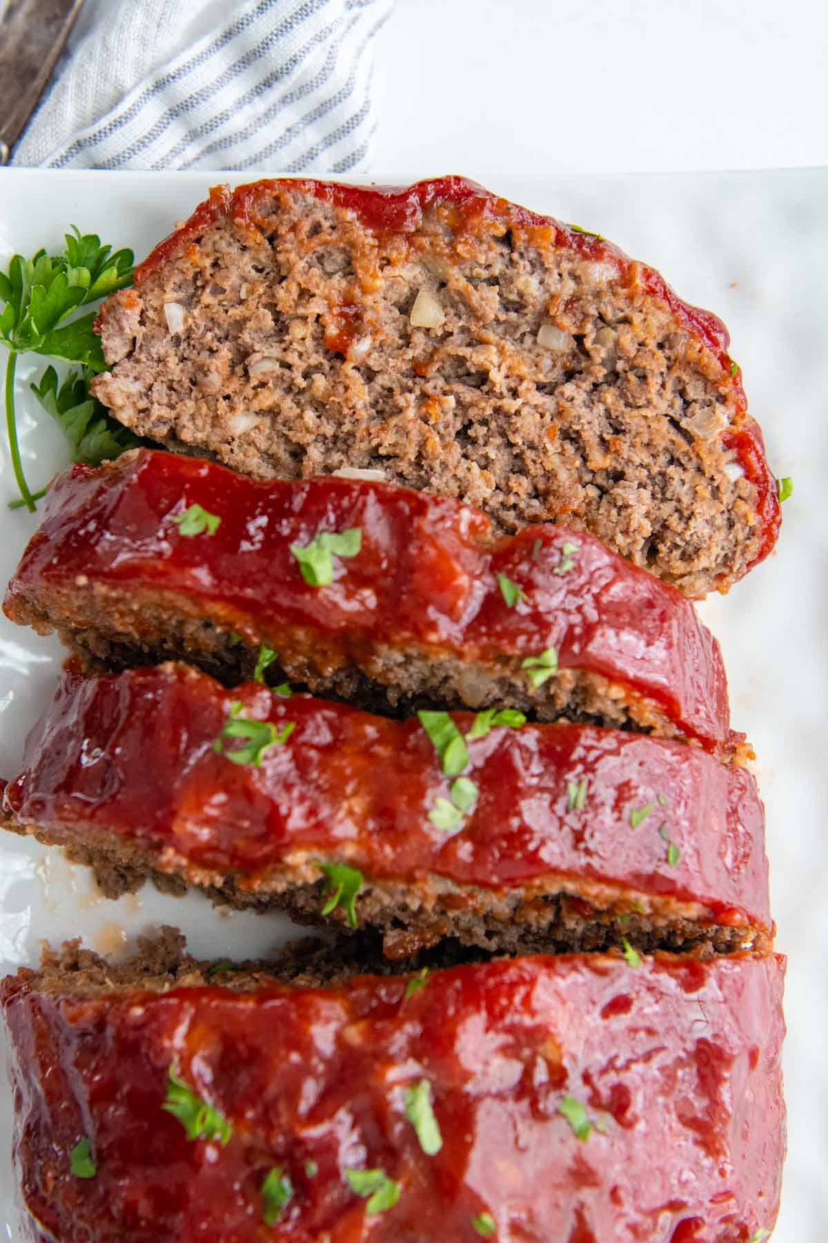 a slice of face up meatloaf on a white plate