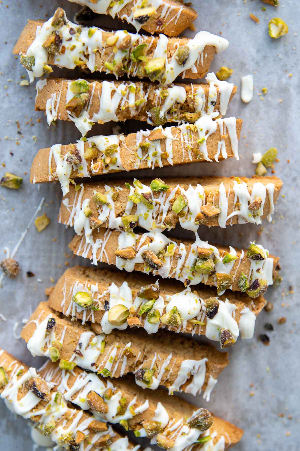 overhead shot of biscotti with white chocolate and pistachios drizzled on top