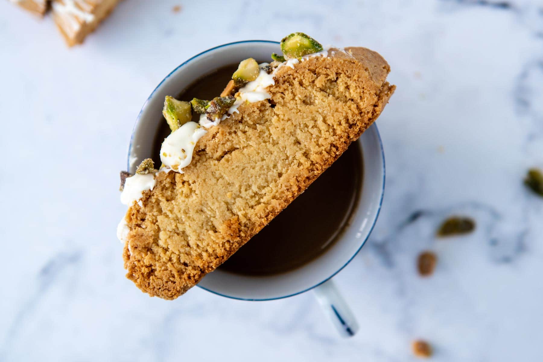almond flour biscotti resting on top of a coffee cup