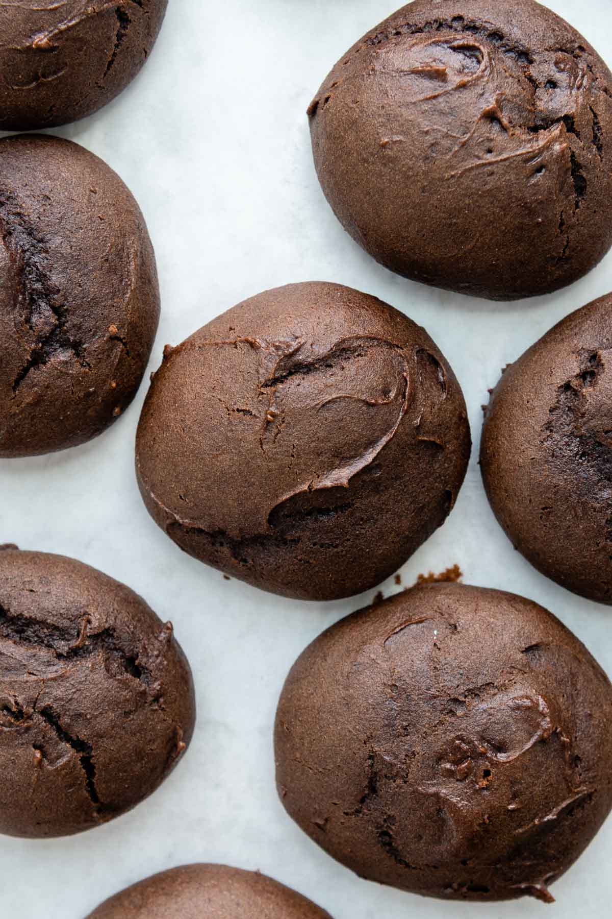 unfilled chocolate cookies on a white surface