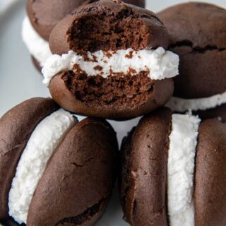 a stack of whoopie pies on a plate with one missing a bite
