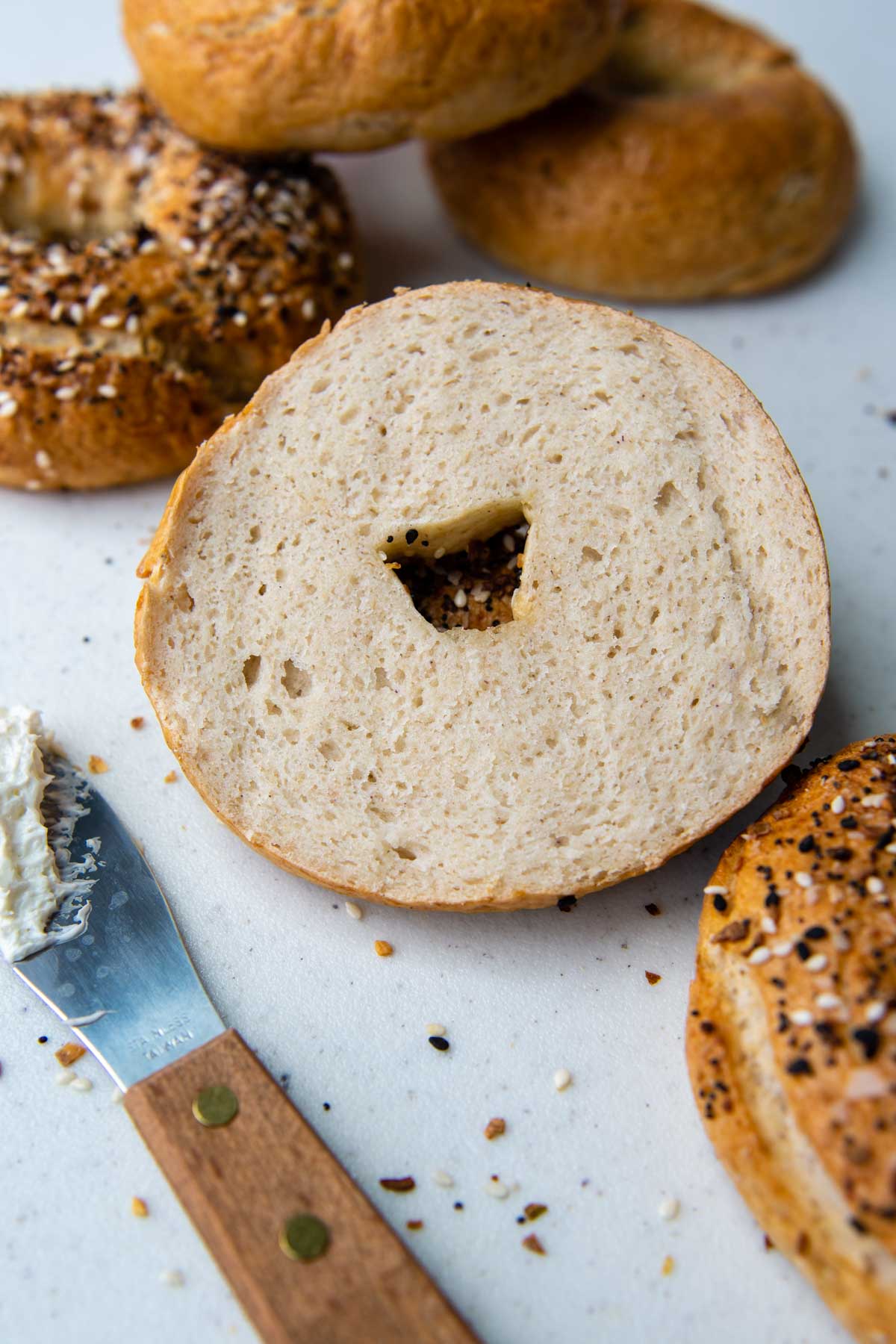 a sliced bagel with other bagels around.