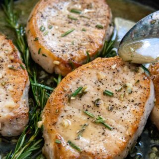 a spoon drizzling sauce over the top of pork chops.