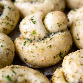 a close up of a garlic knots with garlic butter brushed on.