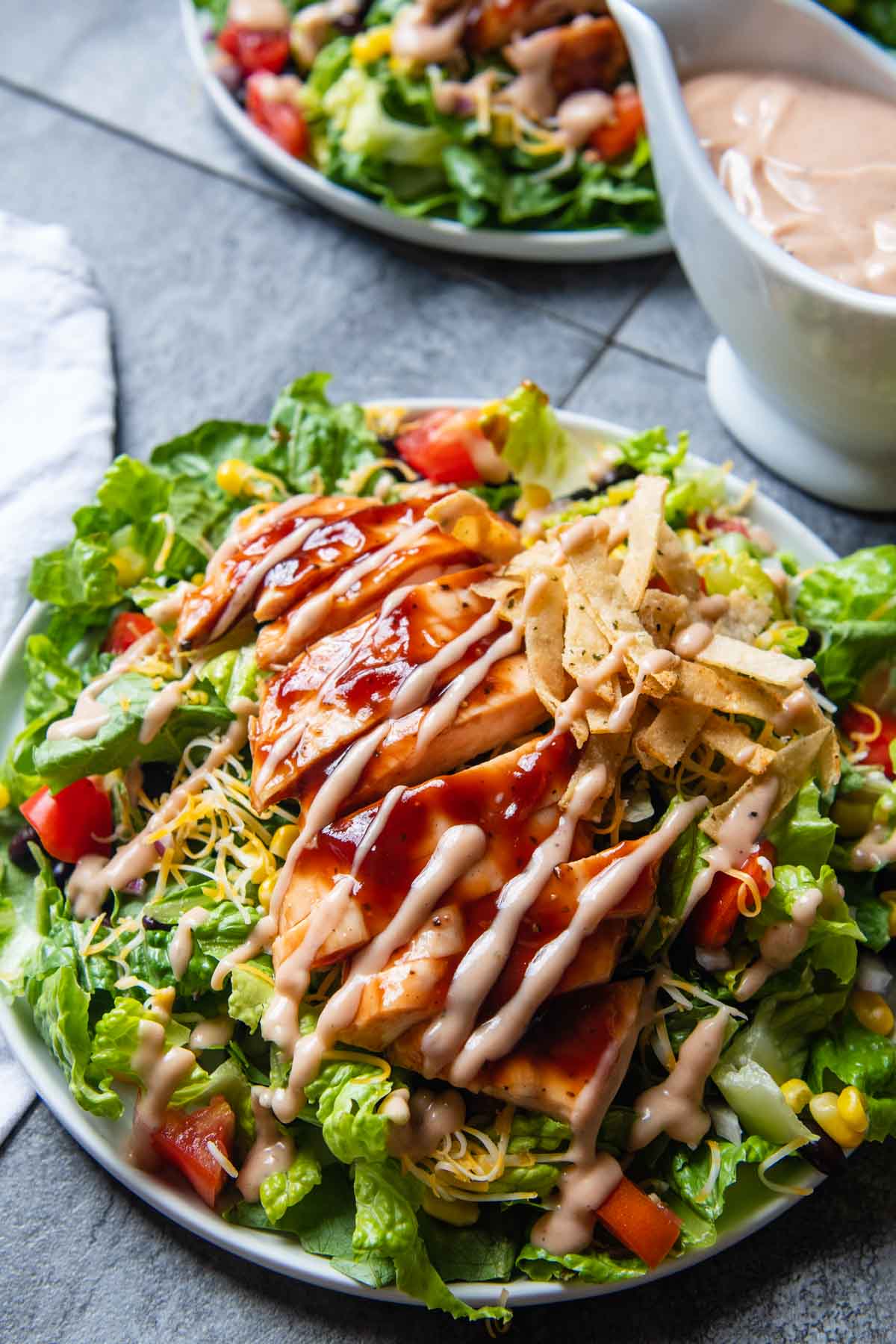 a salad with bbq ranch dressing drizzled on top.