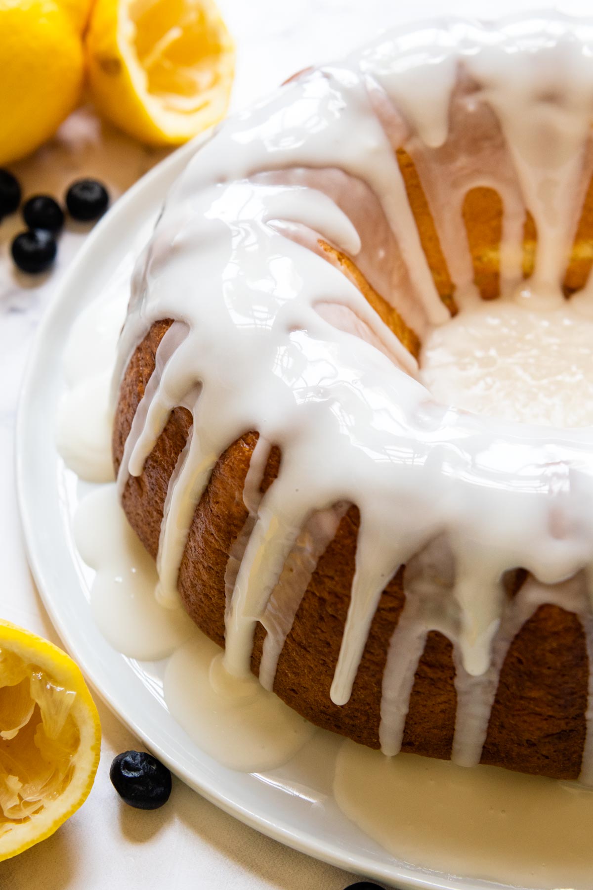 a gluten free lemon cake with frosting drizzled on top.
