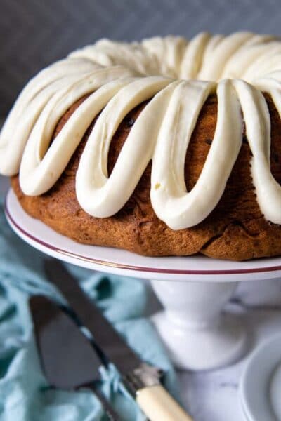 a chocolate chip bundt cake on white cake platter with a knife next to it.