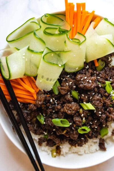 overhead shot of bulgogi with carrots, green onions, and cucumbers.