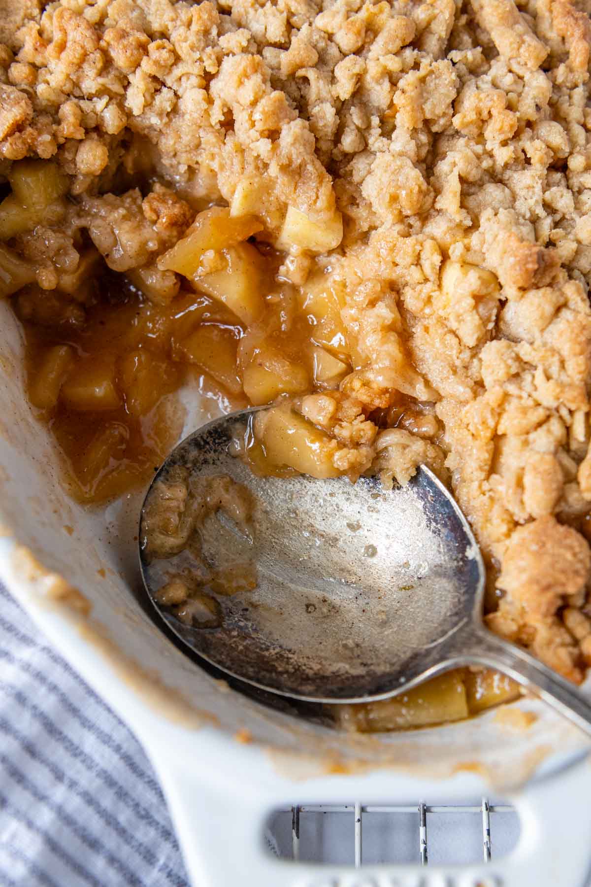a spoon going into a close up of apple crisp.