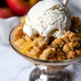 a serving of gluten free apple crisp with scoop of ice cream.