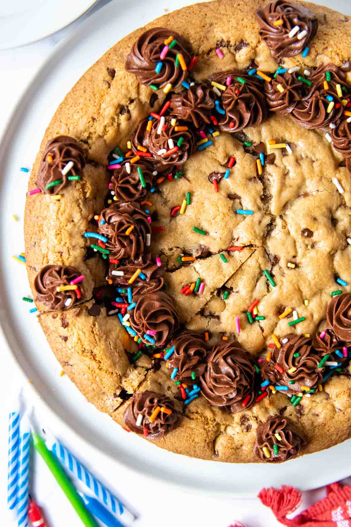 overhead shot of gluten free cookie cake with sprinkles and frosting on top.