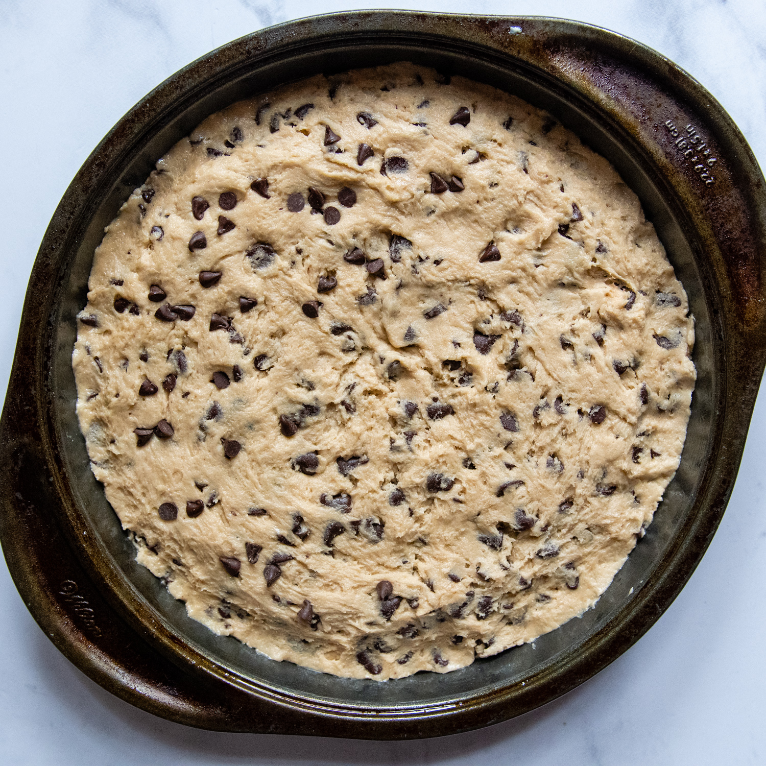 the cookie dough spread into a round baking pan.