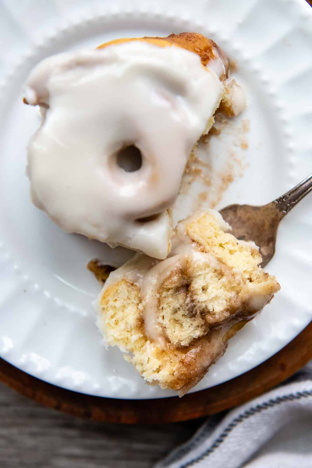 a bite of cinnamon roll on a fork facing up.