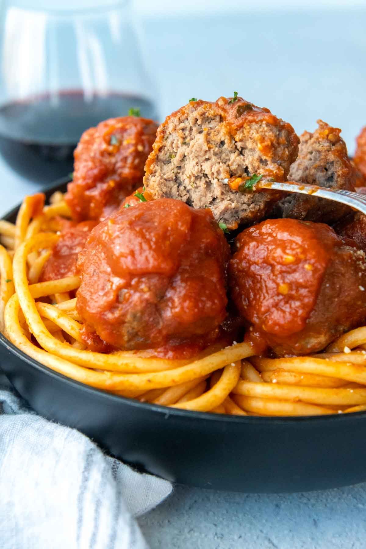 a meatball speared with a fork that has been cup open.