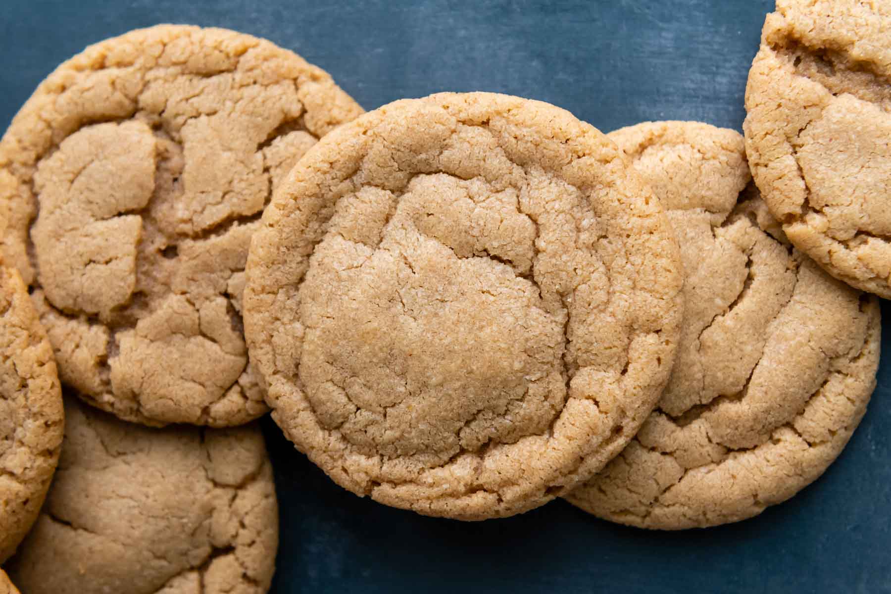 a line of peanut butter cookies on a blue background.