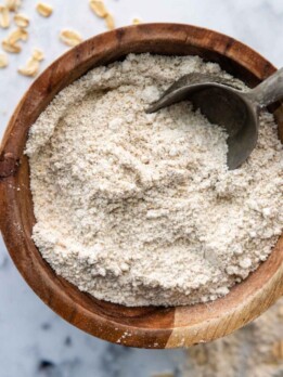 a bowl of oat flour with a scoop in it.