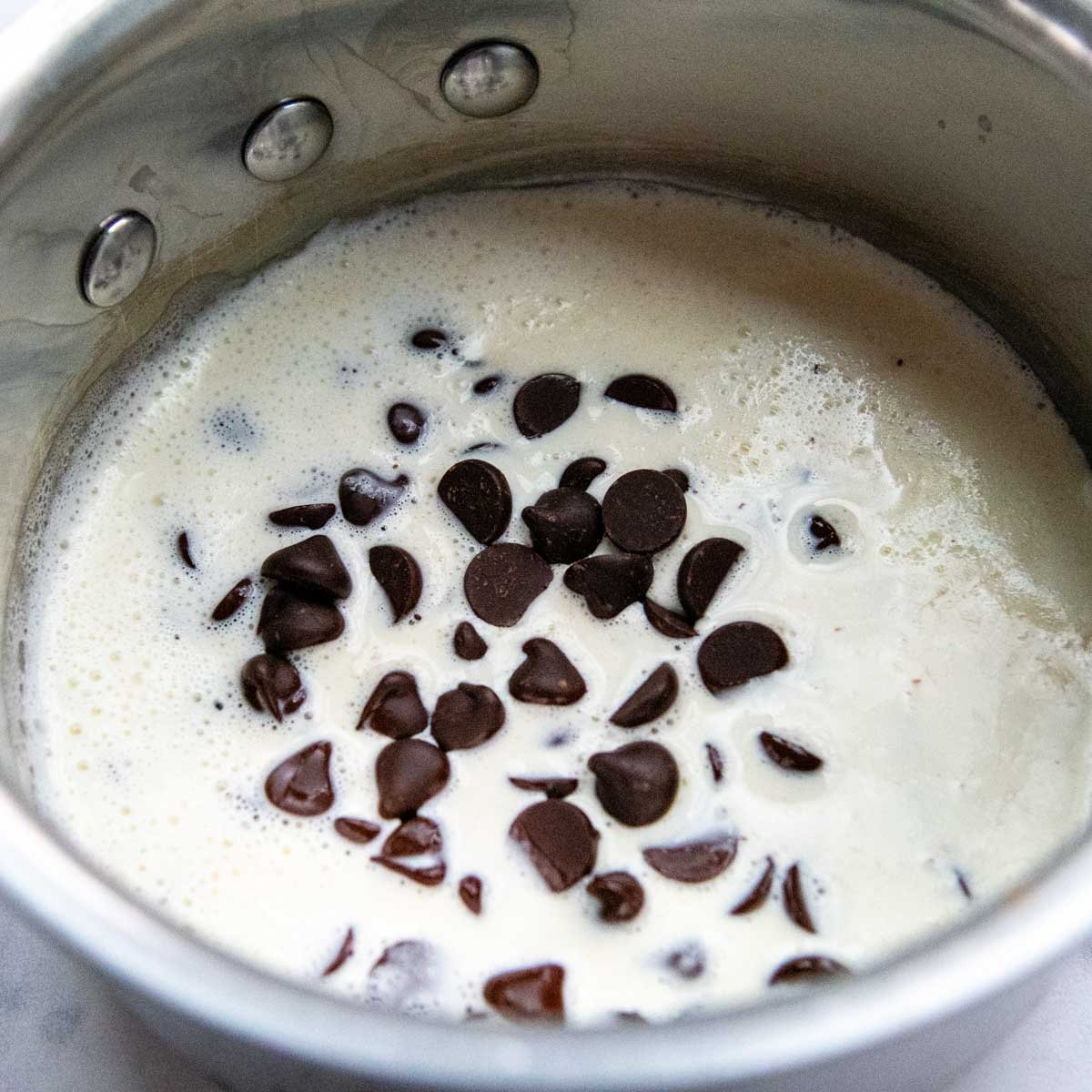 chocolate chips being melted in heavy cream