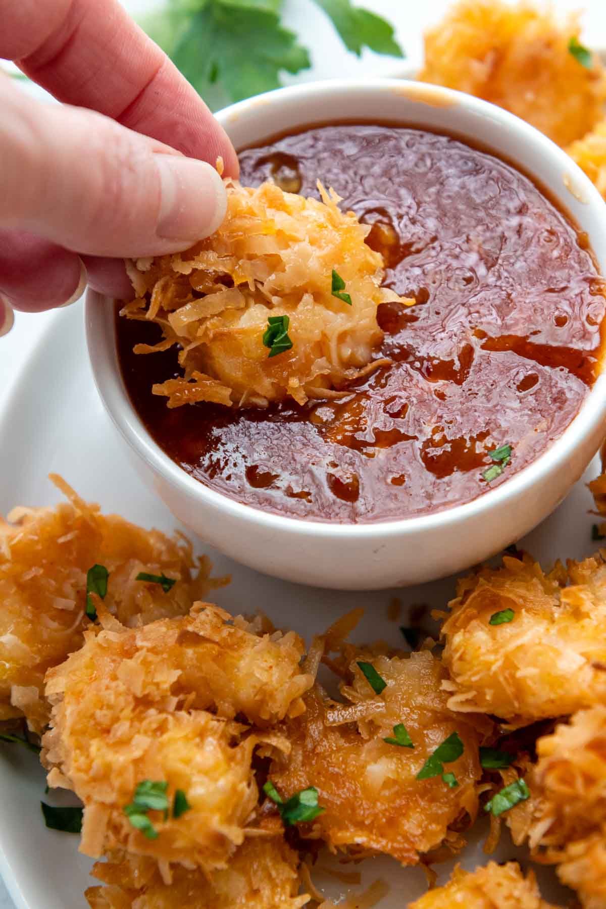 a shrimp being dipped into a sauce.