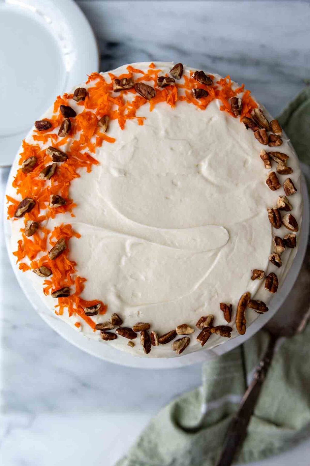 top of cake with grated carrots and nuts.