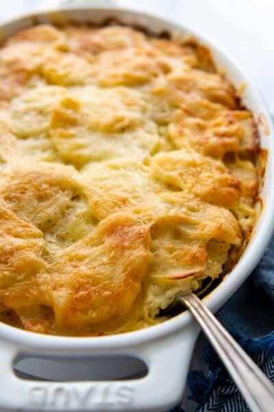 a spoon going into baked au gratin potatoes.