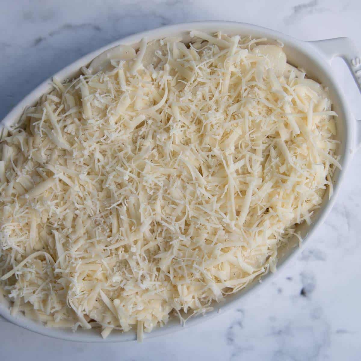 au gratin potatoes layered in a baking dish unbaked.