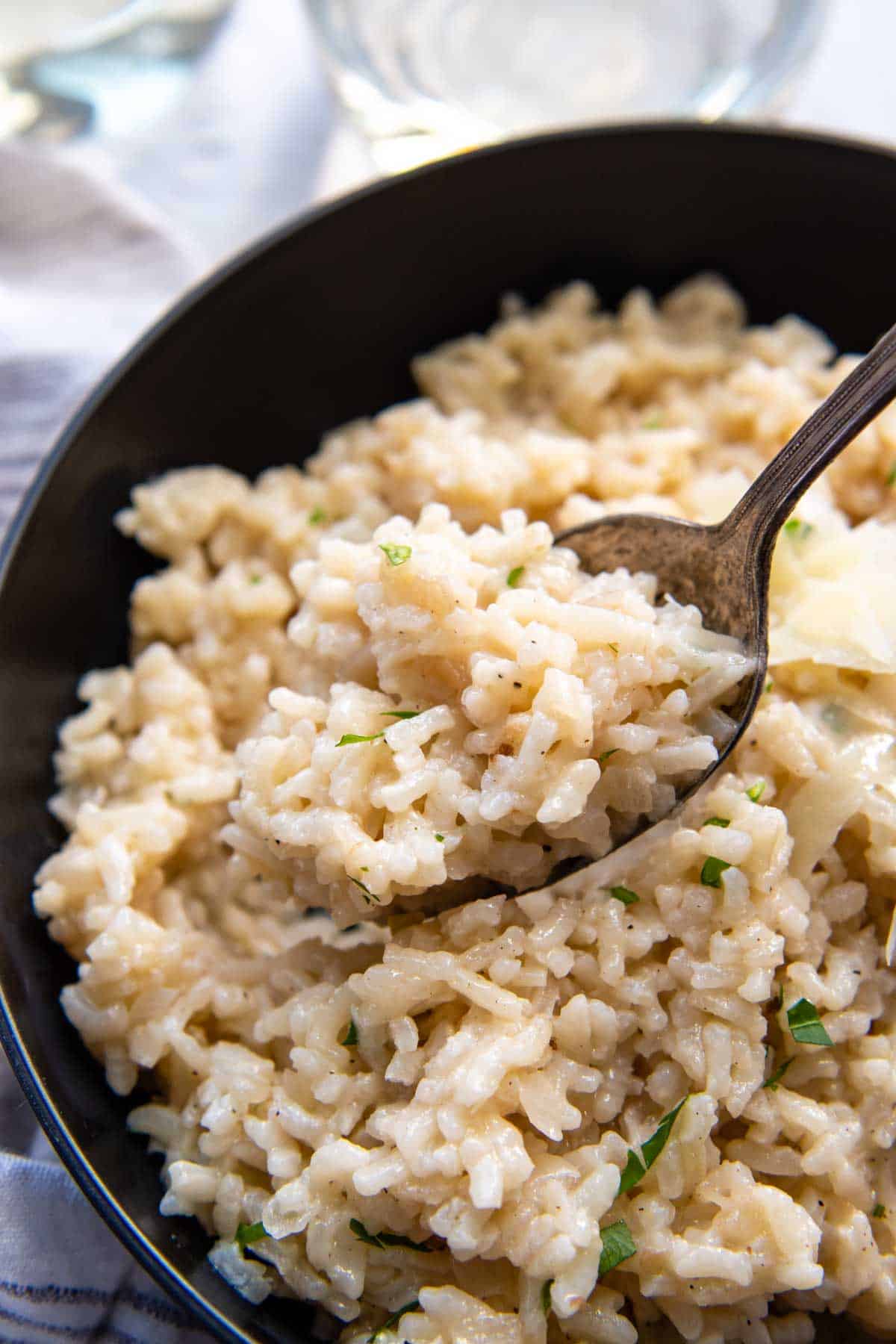 a spoon holding up a bite of risotto.