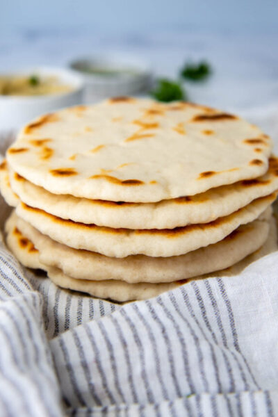 a stack of flatbreads on a white towel.