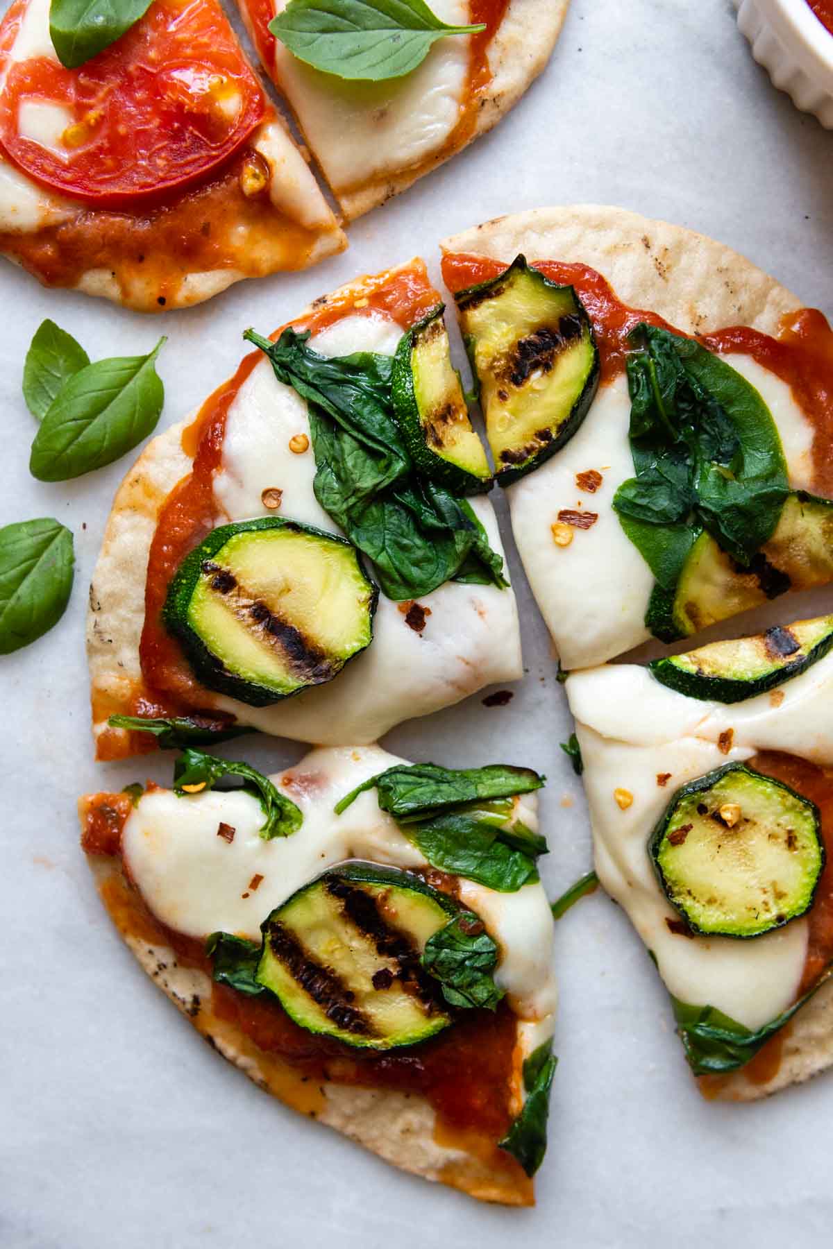 sliced grilled pizza with zucchini on top.