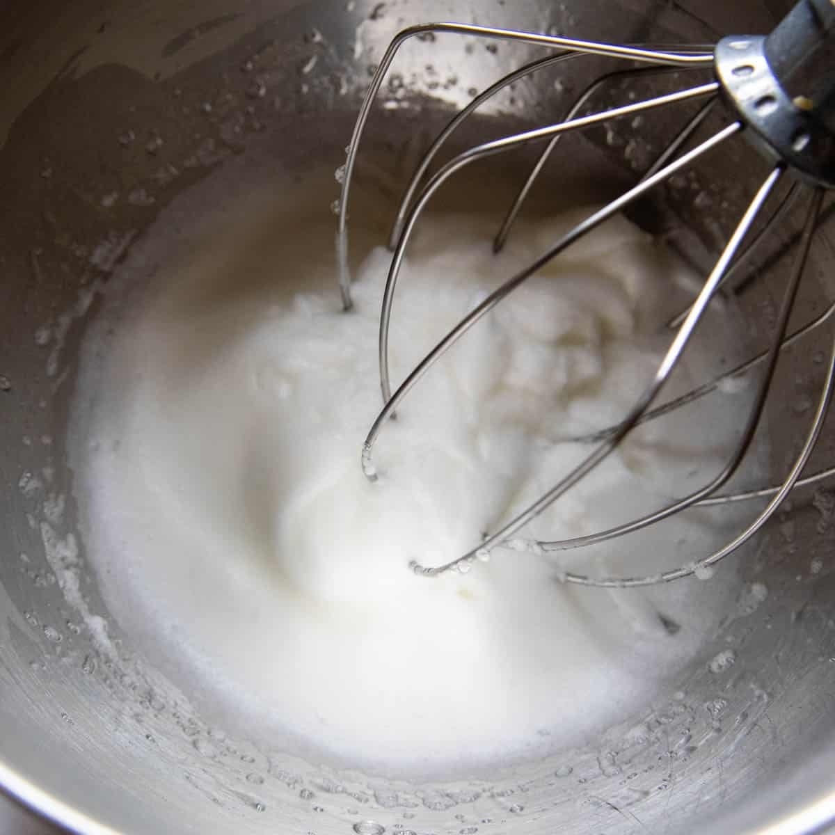 egg whites beaten in a metal bowl.