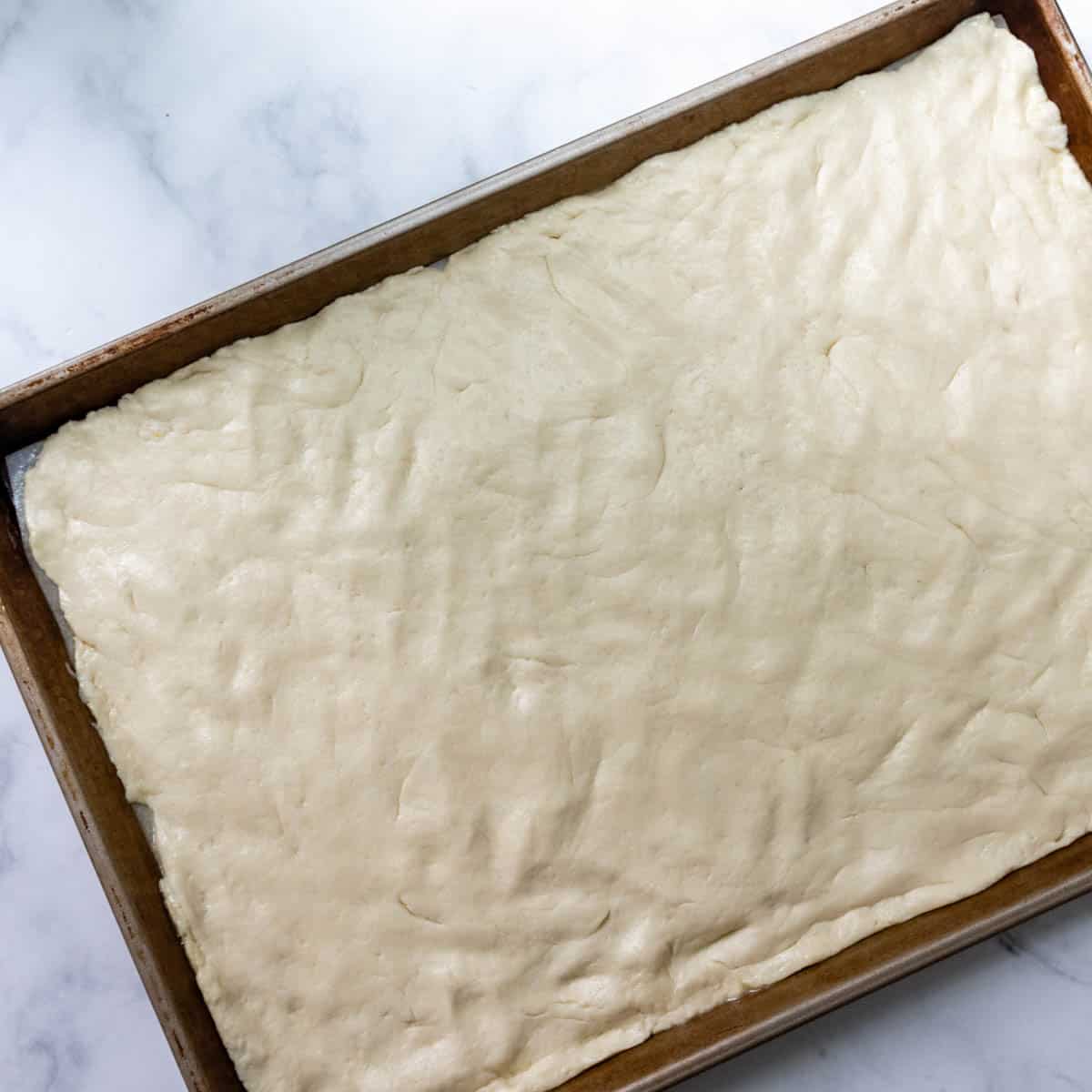 dough patted out onto a baking sheet.