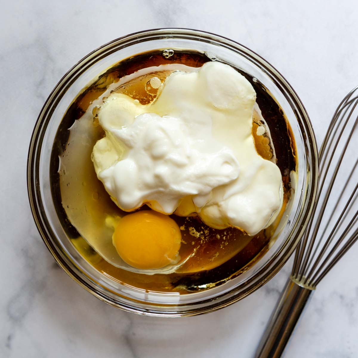 egg, yogurt, oil, and honey in a bowl.