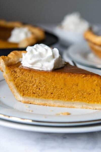 a slice of pumpkin pie on a white plate.