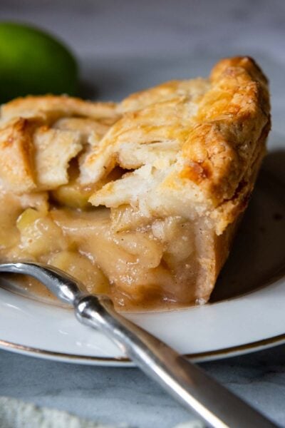 a slice of pie with a fork next to it, close up of the crust.