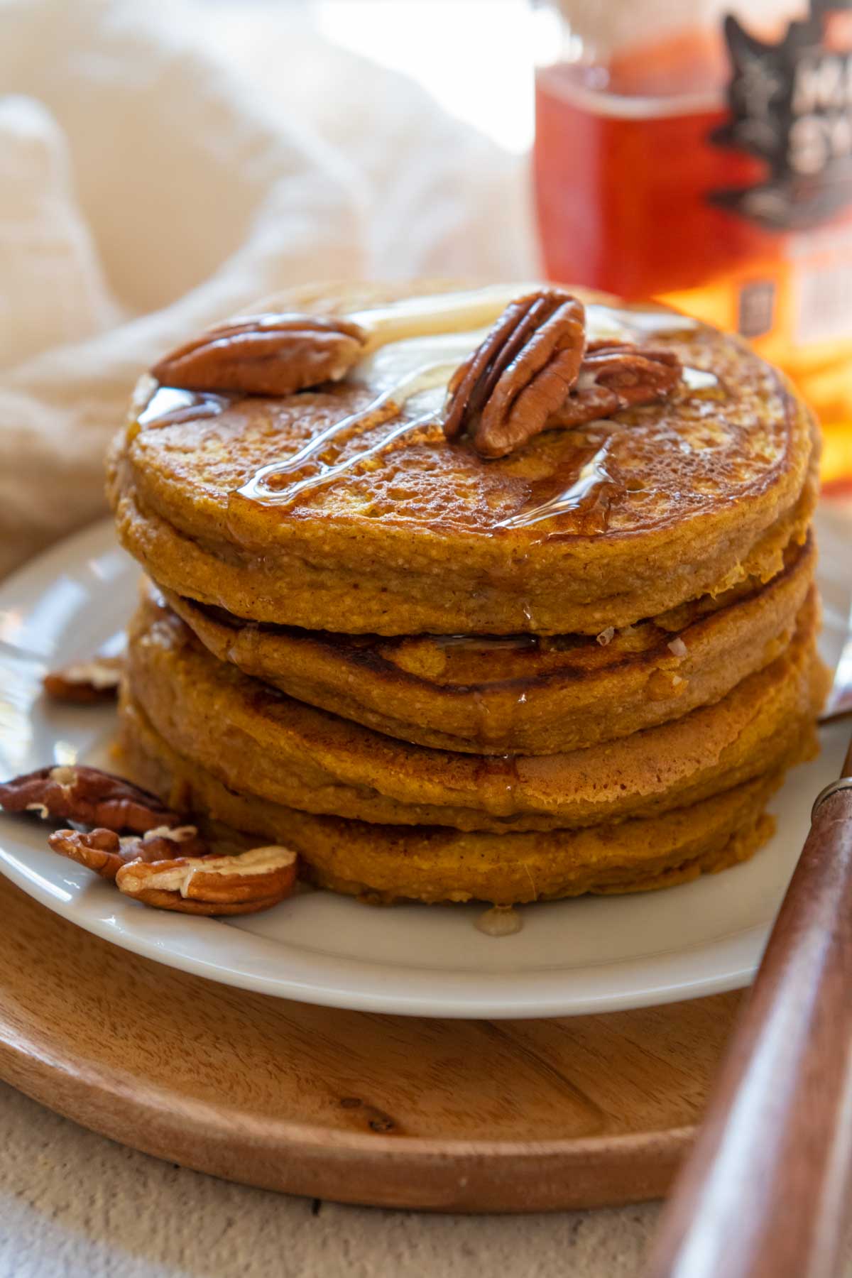 a stack of pancakes with pecans and butter on top.