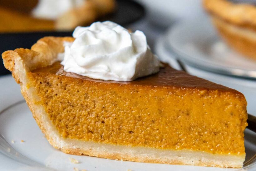 a slice of pumpkin pie on a white plate.