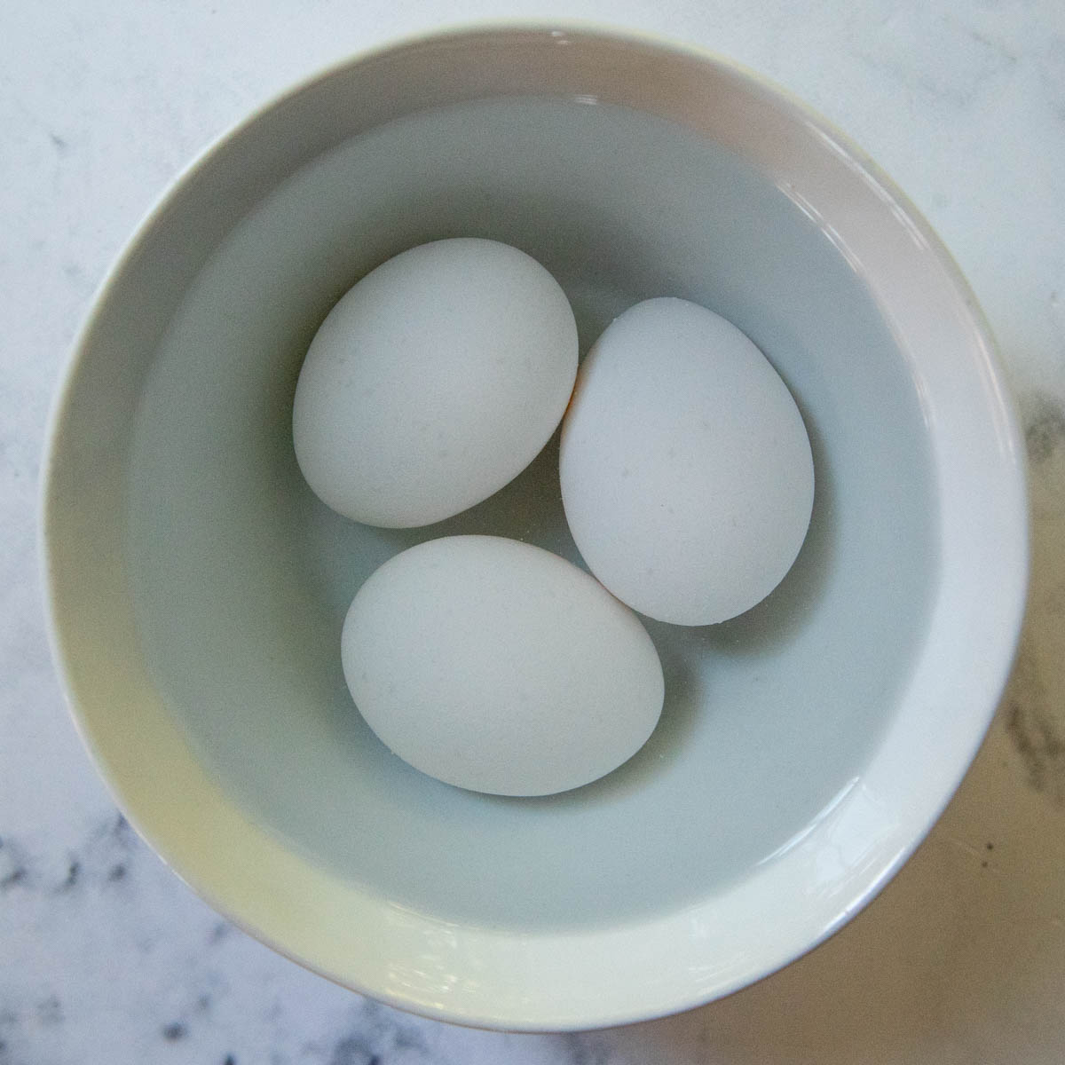 whole eggs in a bowl of water.
