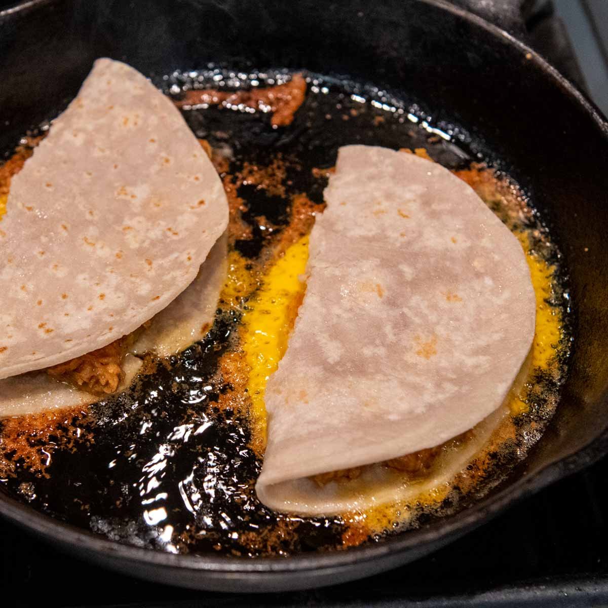a frying pan cooking quesadillas.
