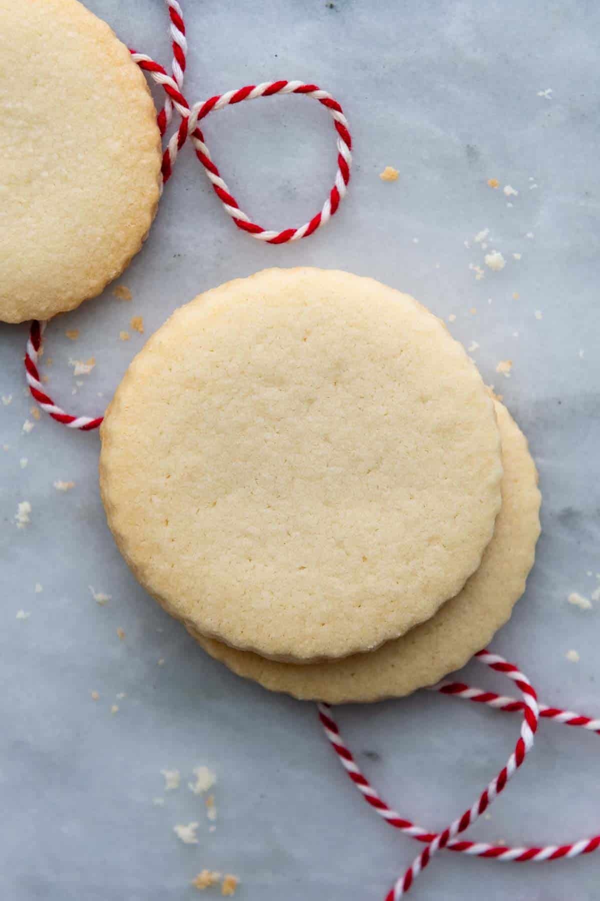 two shortbread cookies stacked with a red thread underneath.