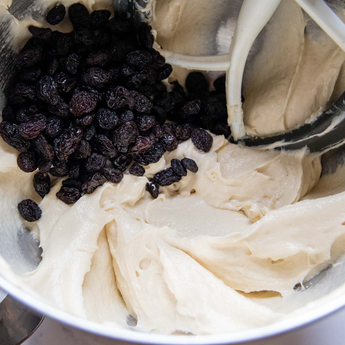 bread dough with raisins in a large bowl.