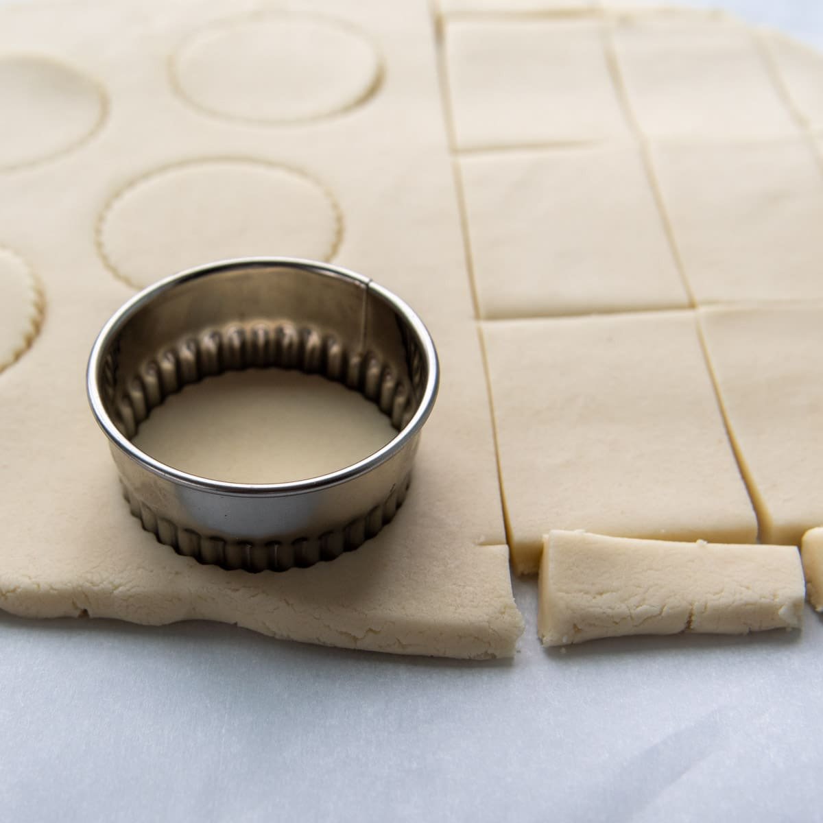 biscuit cutter cutting into rolled out dough.