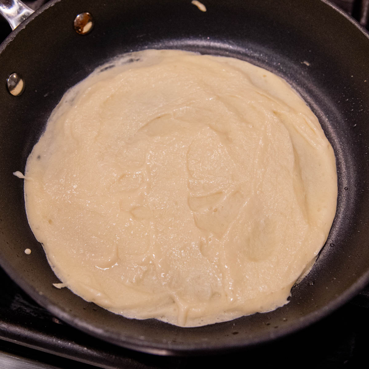 the crepe ready to flip in a pan.