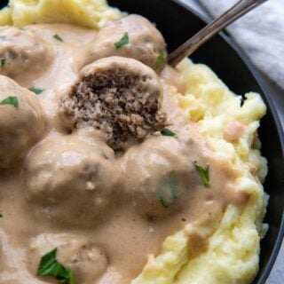 Swedish meatball broke open in a bowl of mashed potatoes.