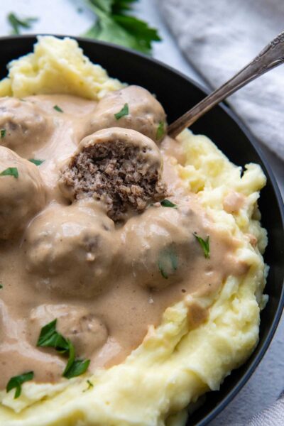 Swedish meatball broke open in a bowl of mashed potatoes.