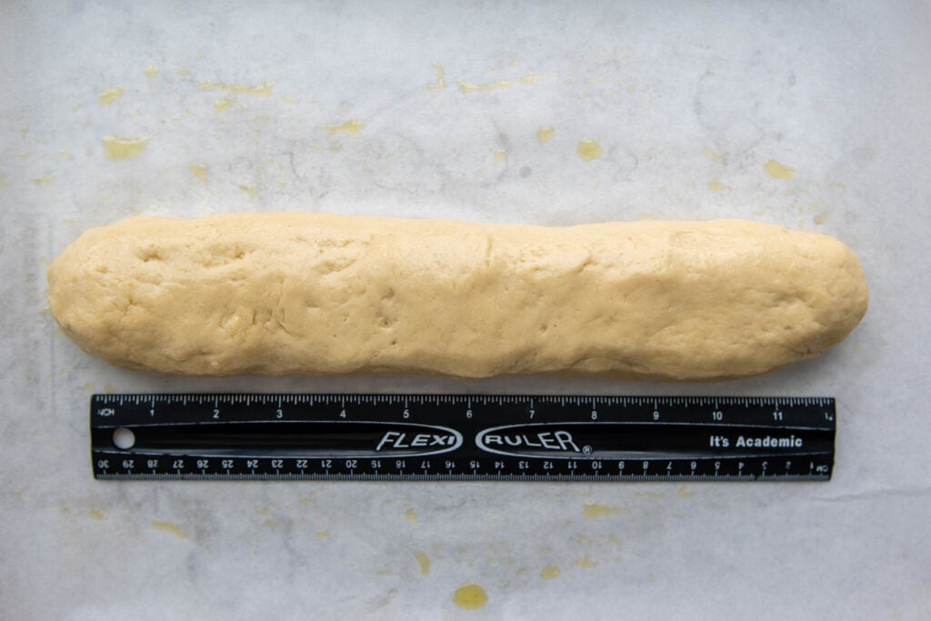a ruler measuring the length of the shaped dough.