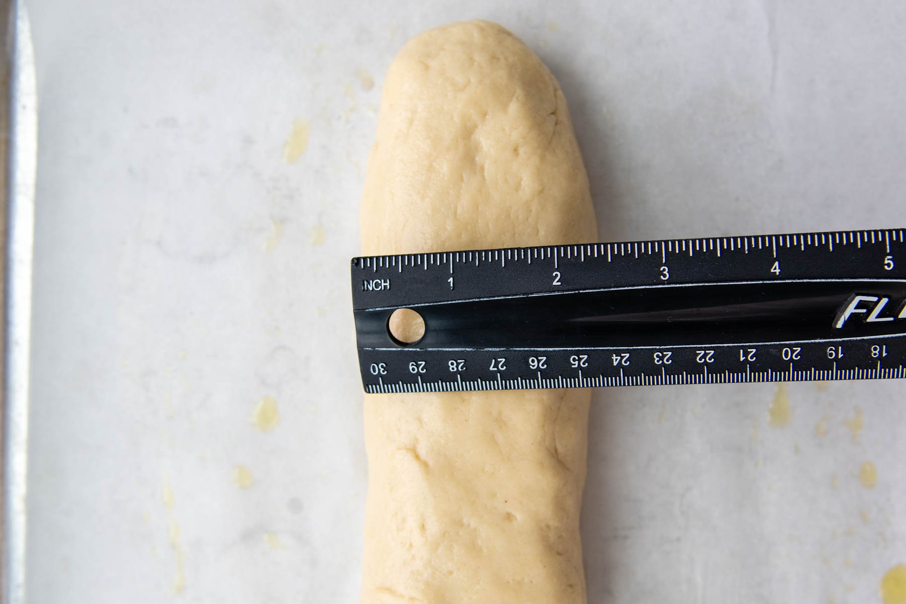 a ruler measuring the width of the shaped dough.