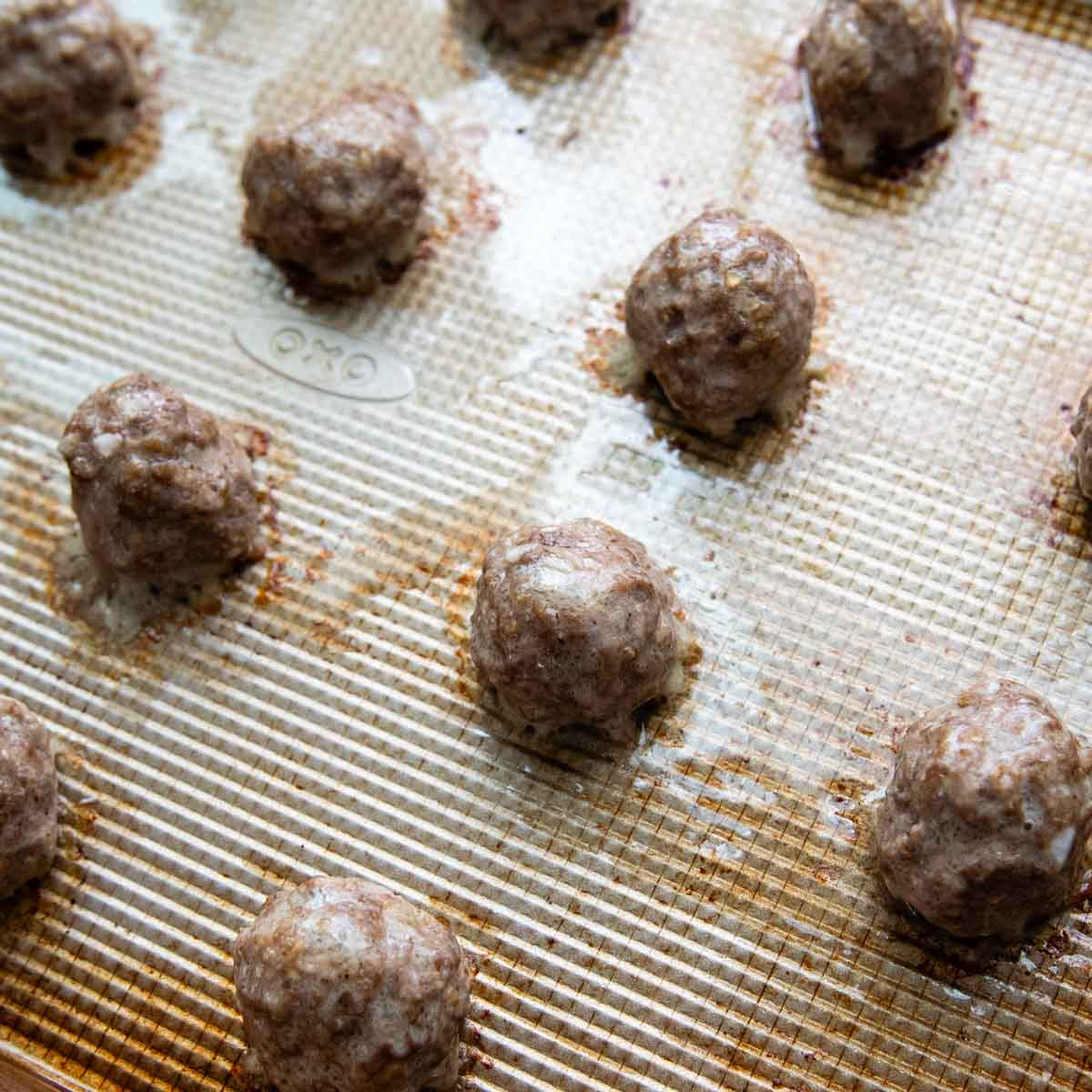 meatballs browned on a baking sheet.